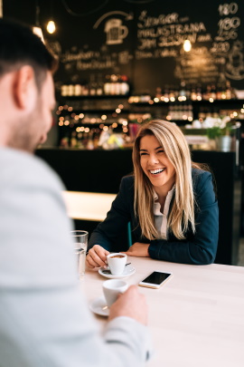 Frau lacht über Witze des Mannes beim Date im Café